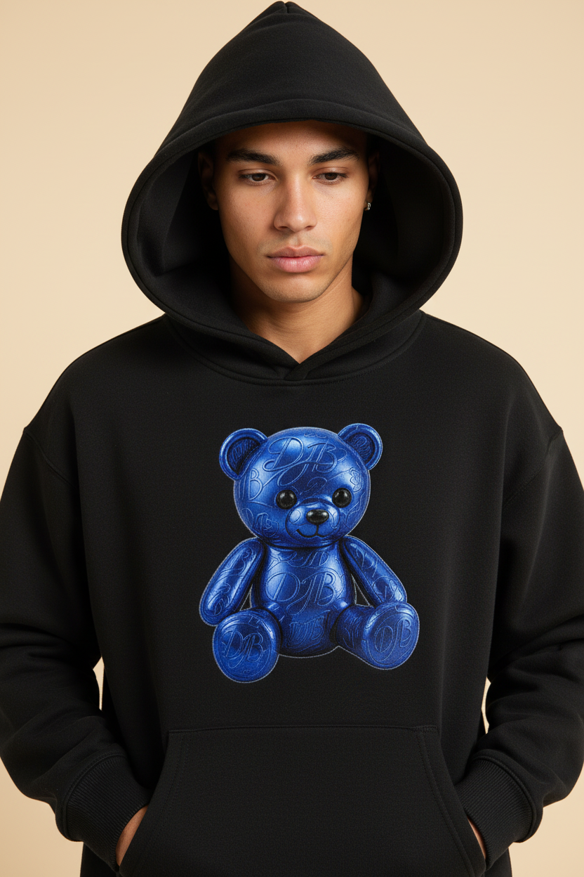 Close-up of the black Teddy Oversize Fleeced Hoodie showing the fleece, hood, ribbing, pocket, stitching, and blue teddy artwork